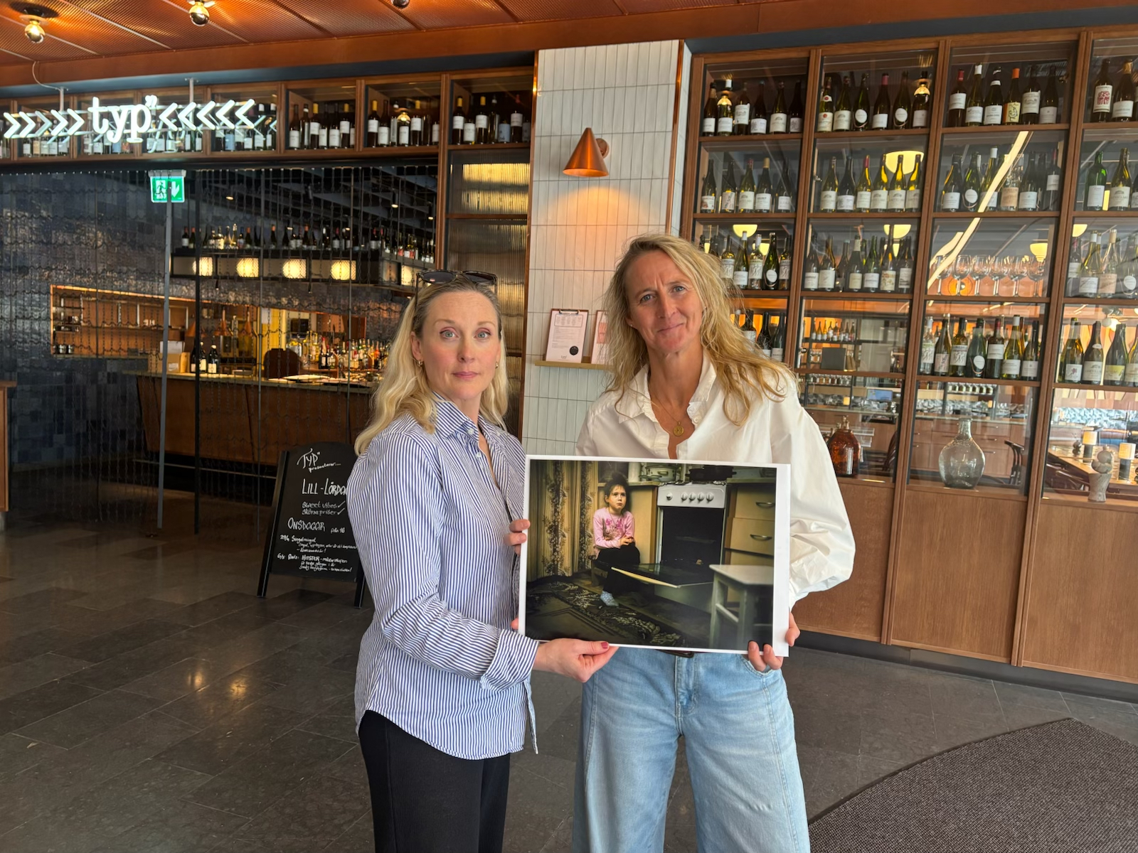 Award-winning press photographer Lotta Härdelin (right) with her donated work
